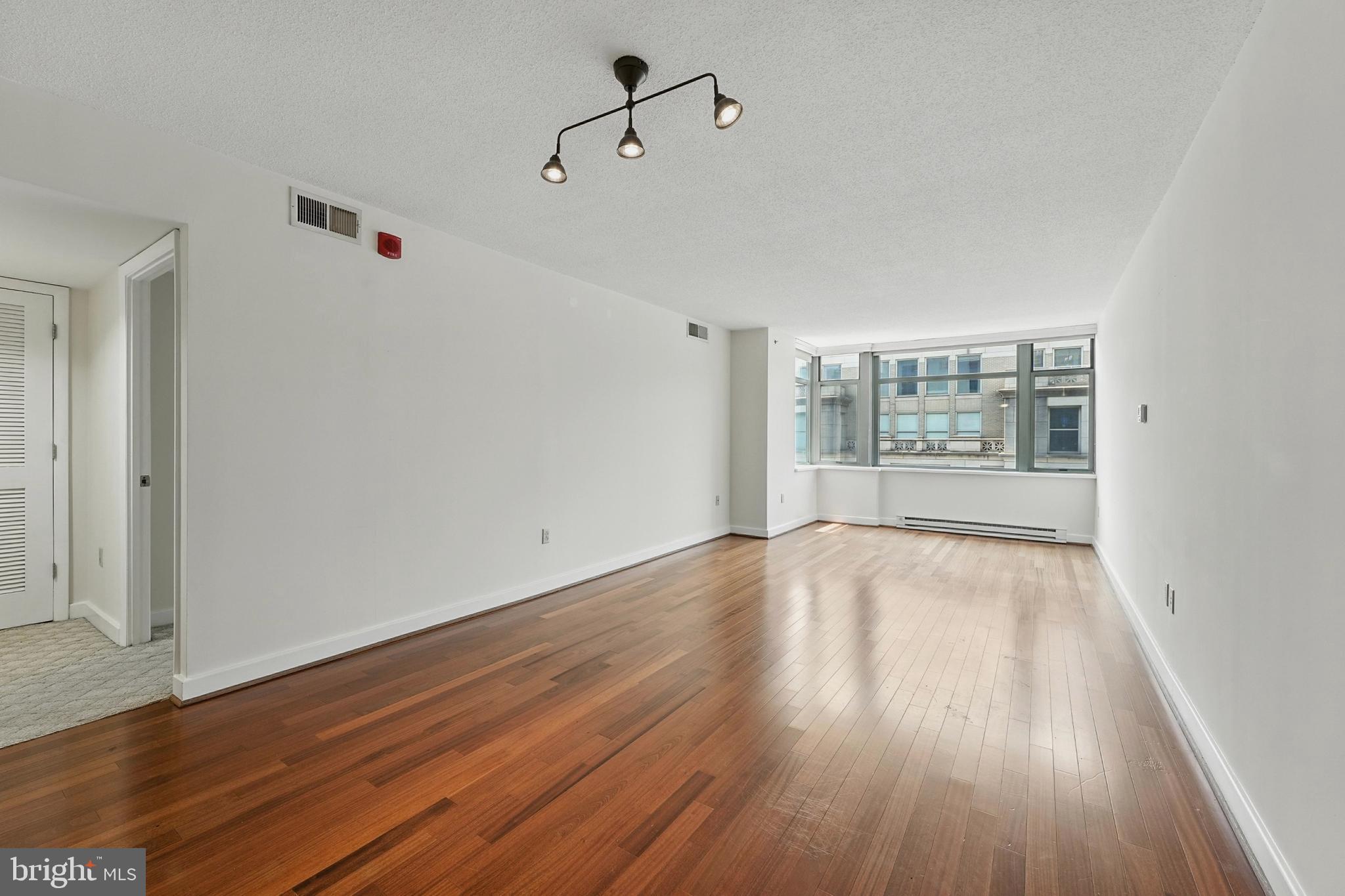 1150 K Street Northwest, Unit 1207 Washington, DC 20005 - Photo 10 of 29 a view of an empty room with wooden floor and a window