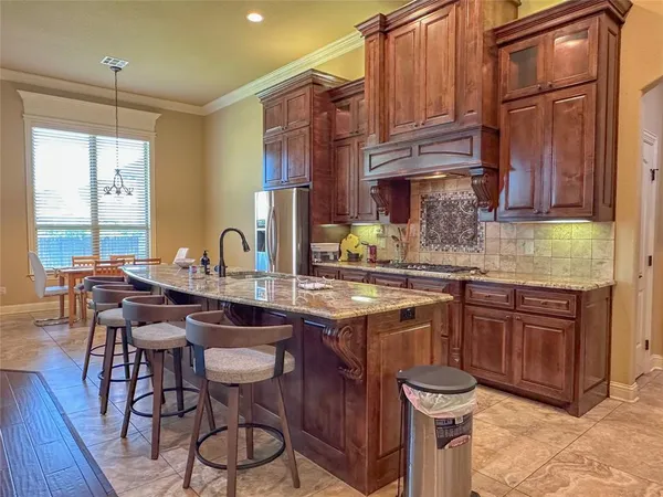 a kitchen with stainless steel appliances granite countertop a refrigerator and wooden cabinets