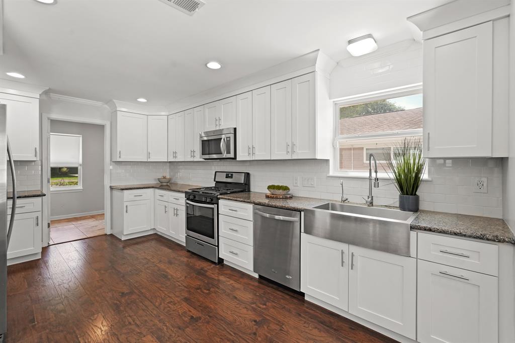 An amazing kitchen! The sizeable kitchen is tastefully upgraded with granite counters, subway tile back splash, soft-close cabinets and drawers, pull-out trash can, pantry, wine rack, stainless steel appliances and farmhouse sink.
