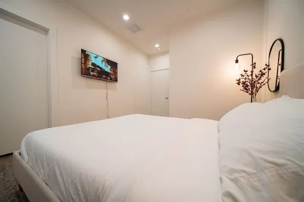 a bedroom with a bed and a flat screen tv