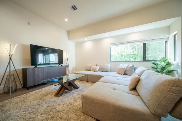 a living room with furniture a window and a flat screen tv