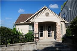 6001 Reims Road, Unit 1202 Houston, TX 77036 - Photo 16 of 16 Charming single-story home with a gabled roof, stone accents, and double French doors. Features a front ramp for easy access and is surrounded by lush greenery, offering a cozy and inviting exterior.
