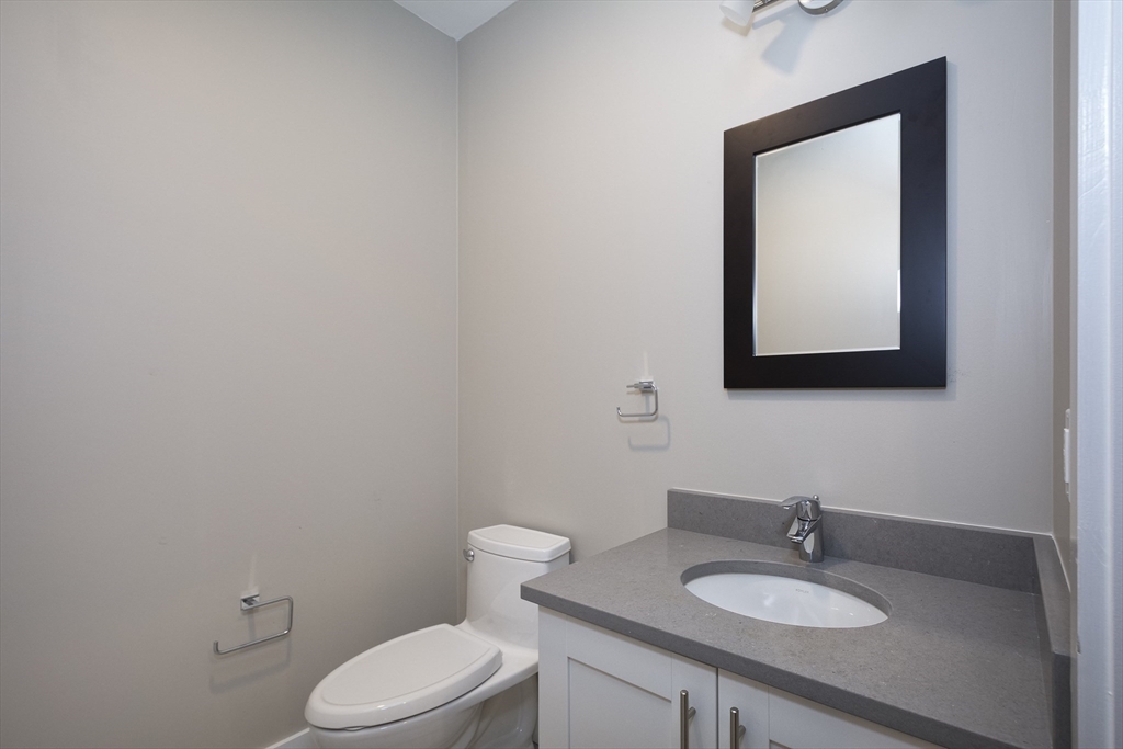 50 Country Way, Unit C204 Scituate, MA 02066 - Photo 11 of 22 a bathroom with a toilet sink vanity and mirror