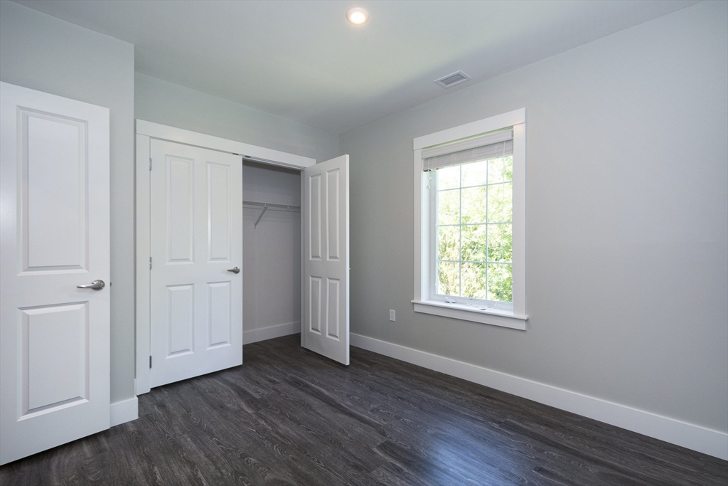 50 Country Way, Unit C204 Scituate, MA 02066 - Photo 13 of 22 a view of an empty room with wooden floor and a window