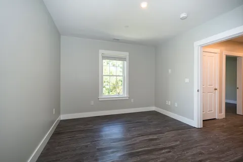 an empty room with wooden floor and window