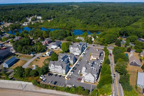 an aerial view of residential houses with outdoor space and trees
