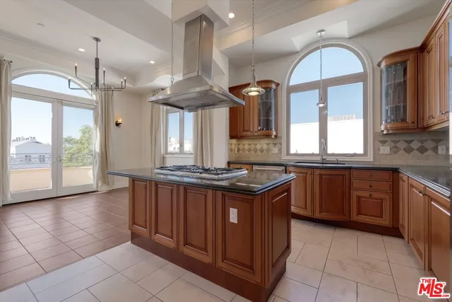 a kitchen with stainless steel appliances granite countertop a stove a sink and a refrigerator