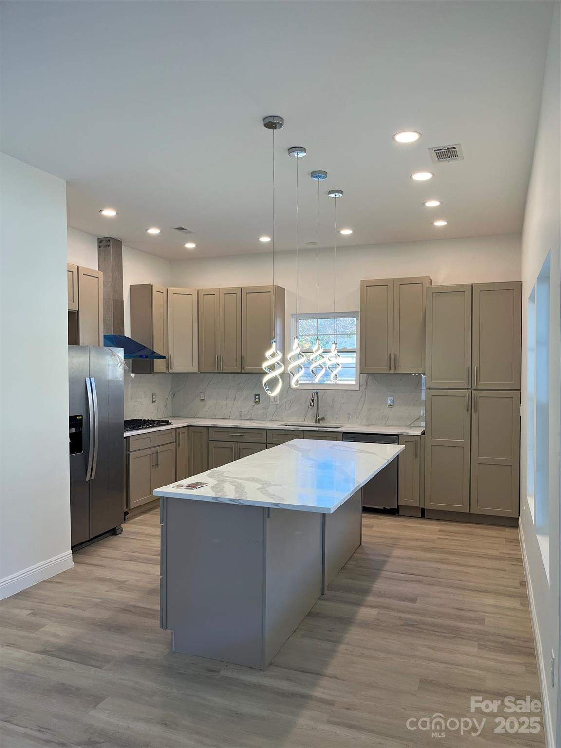 417 Boyte Street Monroe, NC 28110 - Photo 10 of 25 a large kitchen with stainless steel appliances kitchen island a large counter top and a refrigerator