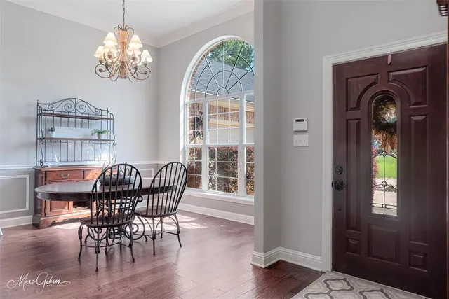 a view of a dining room with furniture wooden floor and chandelier