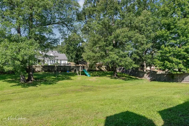a view of a house with a big yard and large trees