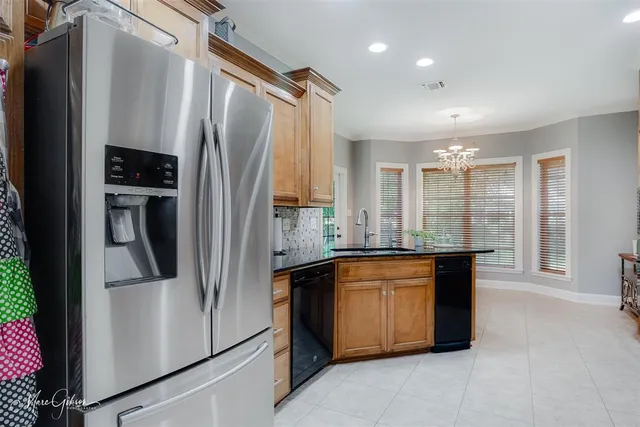 a kitchen with stainless steel appliances granite countertop a refrigerator and a sink