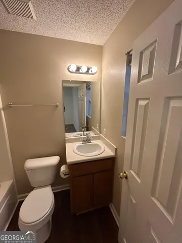 a bathroom with a toilet sink and mirror