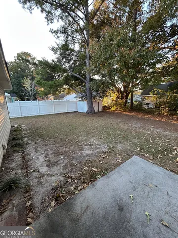 a view of a yard with trees in the background
