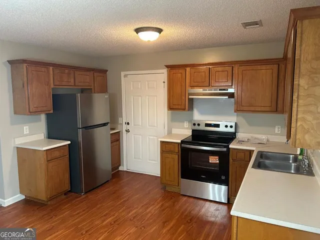a kitchen with wooden floors and appliances