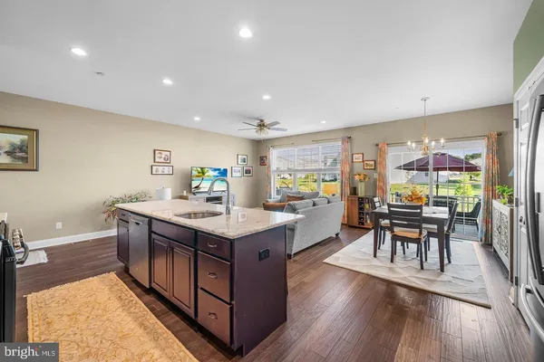 a kitchen with stainless steel appliances granite countertop a table chairs and a refrigerator