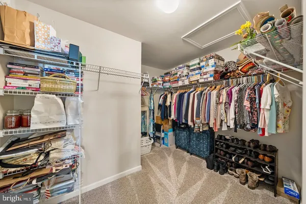 a view of walk in closet with clothes