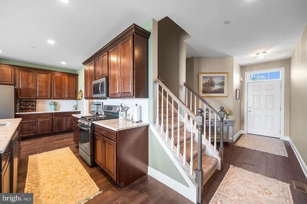 a kitchen with stainless steel appliances granite countertop a refrigerator a stove top oven a sink and dishwasher