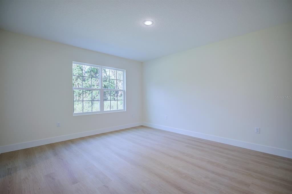 8724 Capilla Street Sebring, FL 33872 - Photo 13 of 33 an empty room with wooden floor and windows