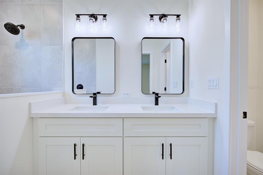 8724 Capilla Street Sebring, FL 33872 - Photo 16 of 33 a bathroom with double vanity sinks and a mirror