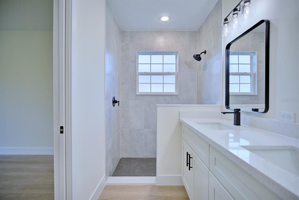 8724 Capilla Street Sebring, FL 33872 - Photo 17 of 33 a bathroom with double vanity sink a two mirror and a window