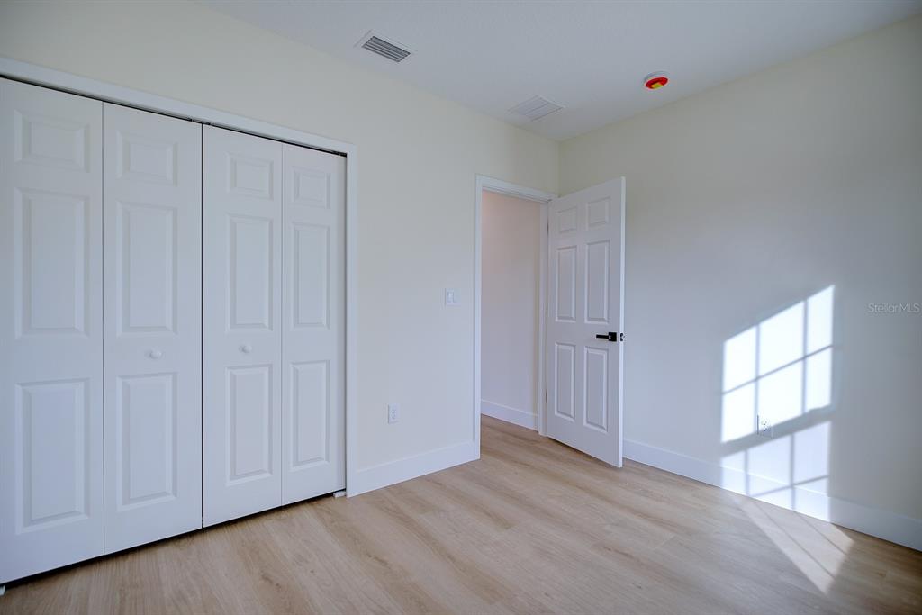 8724 Capilla Street Sebring, FL 33872 - Photo 21 of 33 a view of an empty room with wooden floor and a window