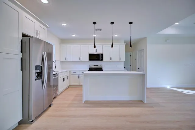 a kitchen with stainless steel appliances a refrigerator sink and microwave