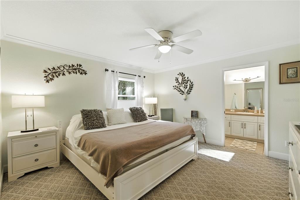 5968 Southwest 103rd Loop Ocala, FL 34476 - Photo 11 of 48 a bedroom with a large bed and a chandelier