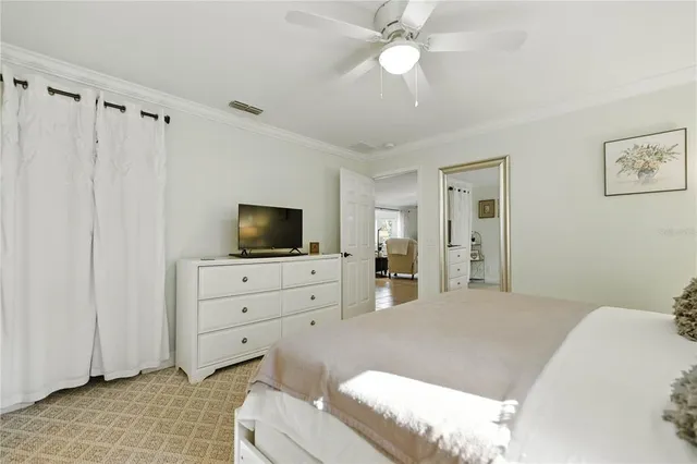 a bedroom with a bed a flat screen tv and dresser
