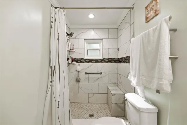 a bathroom with a granite countertop shower a toilet and a sink