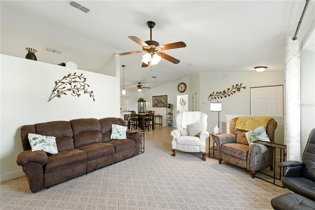 5968 Southwest 103rd Loop Ocala, FL 34476 - Photo 17 of 48 a living room with furniture ceiling fan and a rug