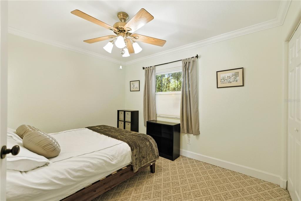 5968 Southwest 103rd Loop Ocala, FL 34476 - Photo 18 of 48 a bedroom with a bed and a chandelier