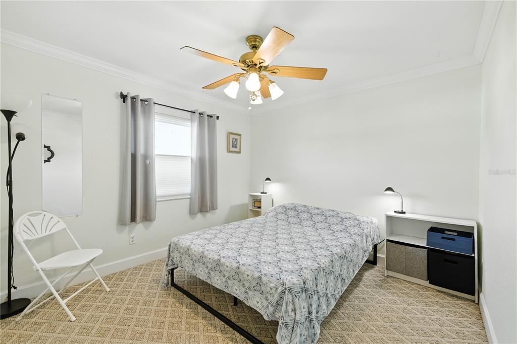 5968 Southwest 103rd Loop Ocala, FL 34476 - Photo 21 of 48 a bedroom with a bed and a chandelier