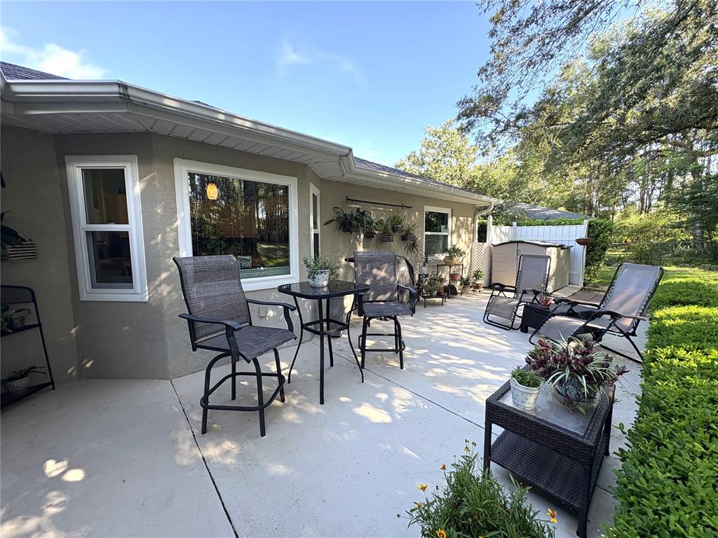 5968 Southwest 103rd Loop Ocala, FL 34476 - Photo 23 of 48 a view of a patio with table and chairs potted plants and floor to ceiling window