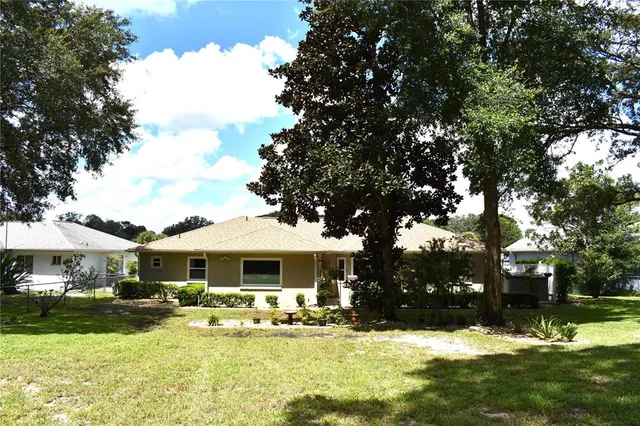 a view of a house with yard and sitting area