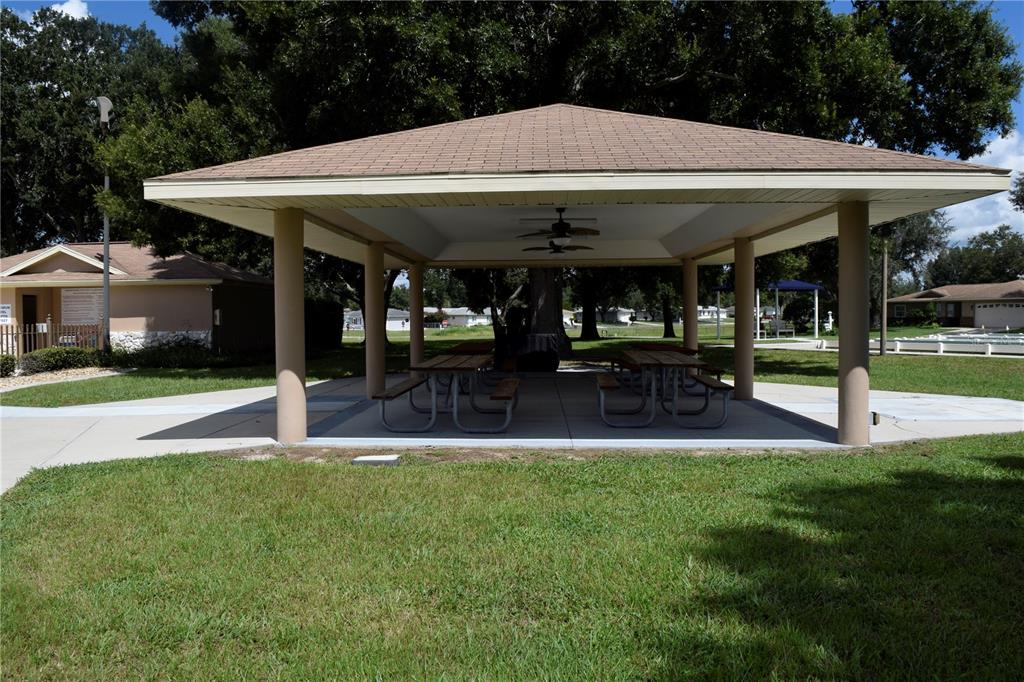 5968 Southwest 103rd Loop Ocala, FL 34476 - Photo 44 of 48 a patio with a table and chairs under an umbrella