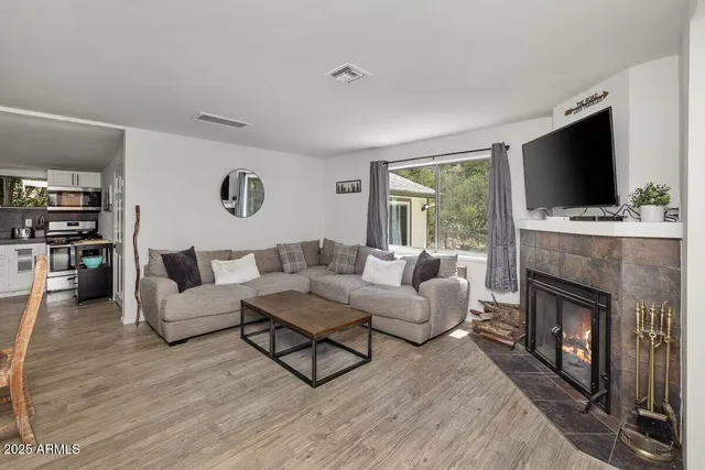 a living room with furniture a flat screen tv and a fireplace