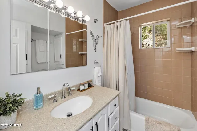 a bathroom with a sink vanity granite tub and shower