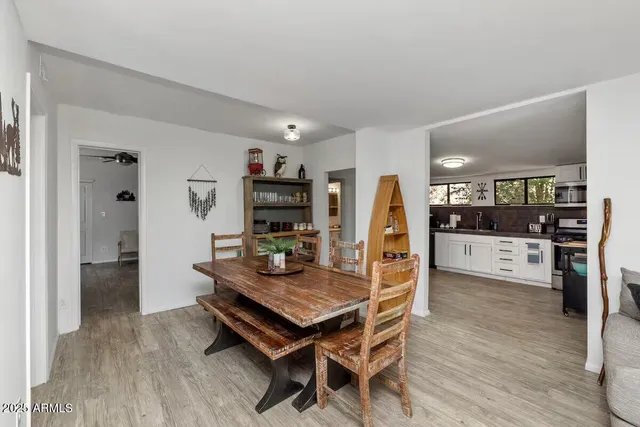 a living room with stainless steel appliances furniture a rug and a kitchen view