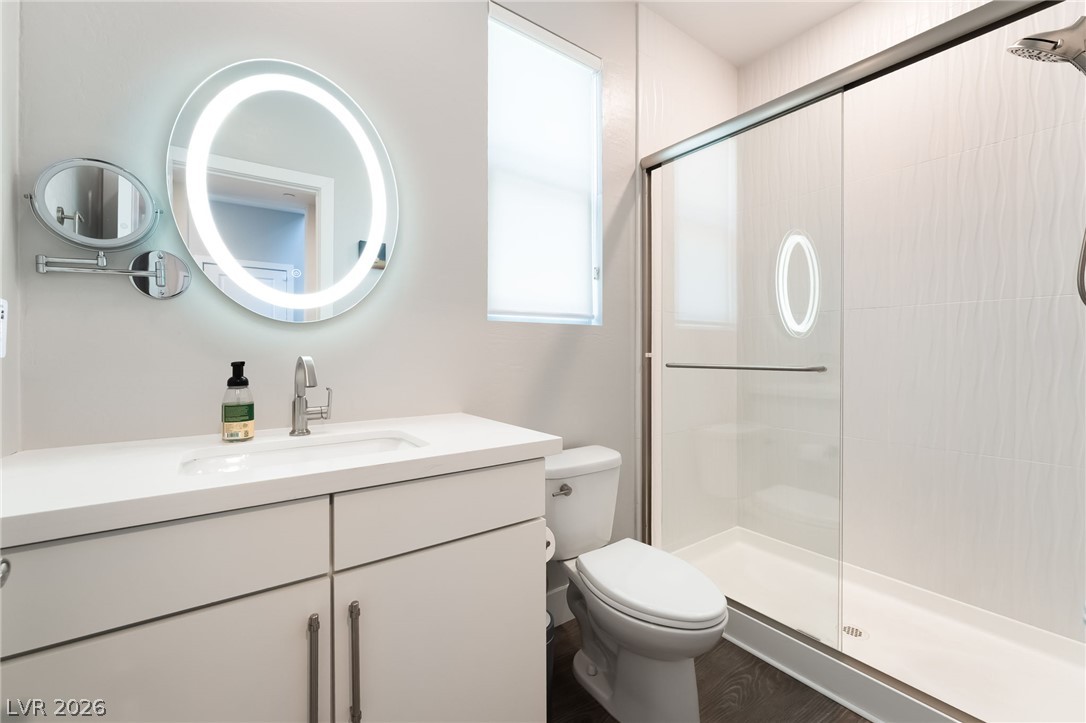 2166 Trivero Street Henderson, NV 89044 - Photo 17 of 61 A streamlined vanity and brightly lit mirror enhance this modern bathroom with a glass-enclosed shower.