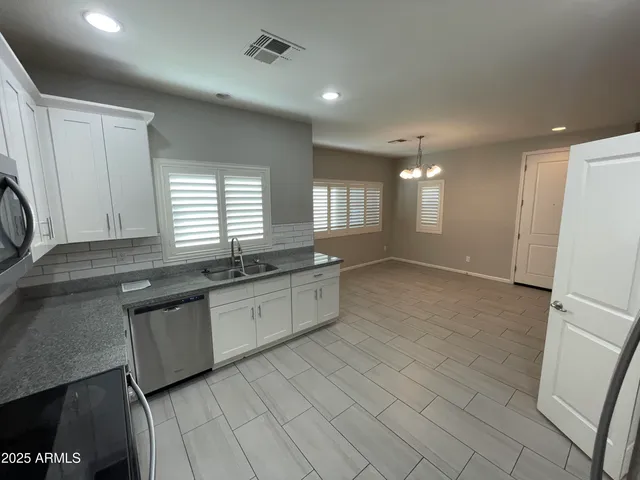 a large kitchen with granite countertop a stove a sink and a refrigerator