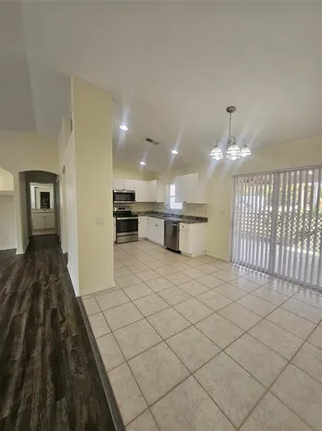 a view of a kitchen with kitchen island white cabinets and black appliances