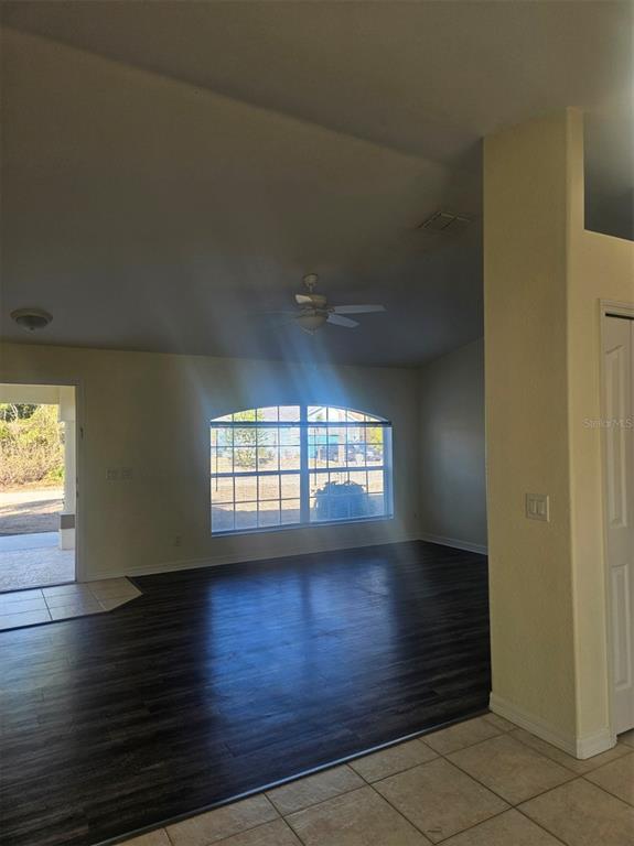 4138 Azora Street North Port, FL 34291 - Photo 12 of 37 an empty room with wooden floor and windows