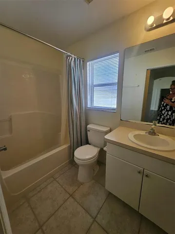 a bathroom with a granite countertop sink toilet a mirror and shower