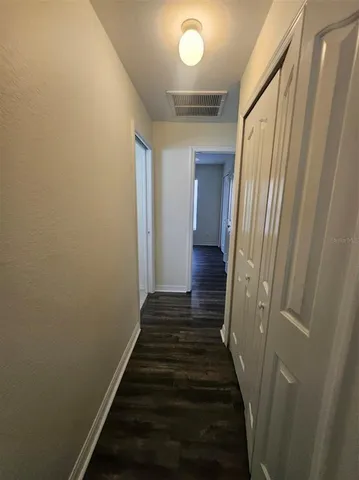 a view of a hallway with wooden floor and staircase
