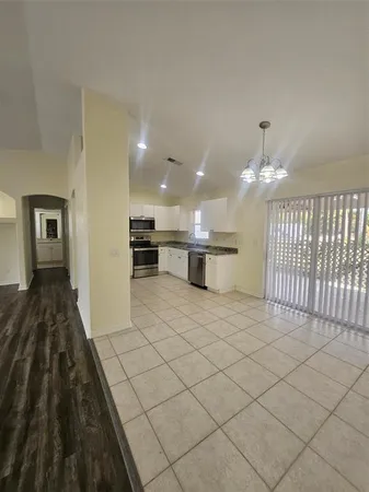 a view of a kitchen with kitchen island white cabinets and black appliances