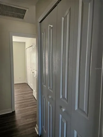 a view of a hallway with wooden floor
