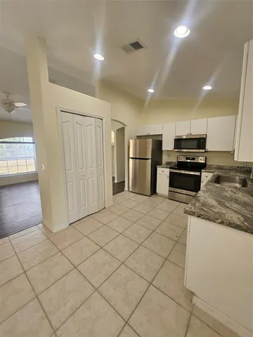 a kitchen with stainless steel appliances granite countertop a refrigerator and a stove