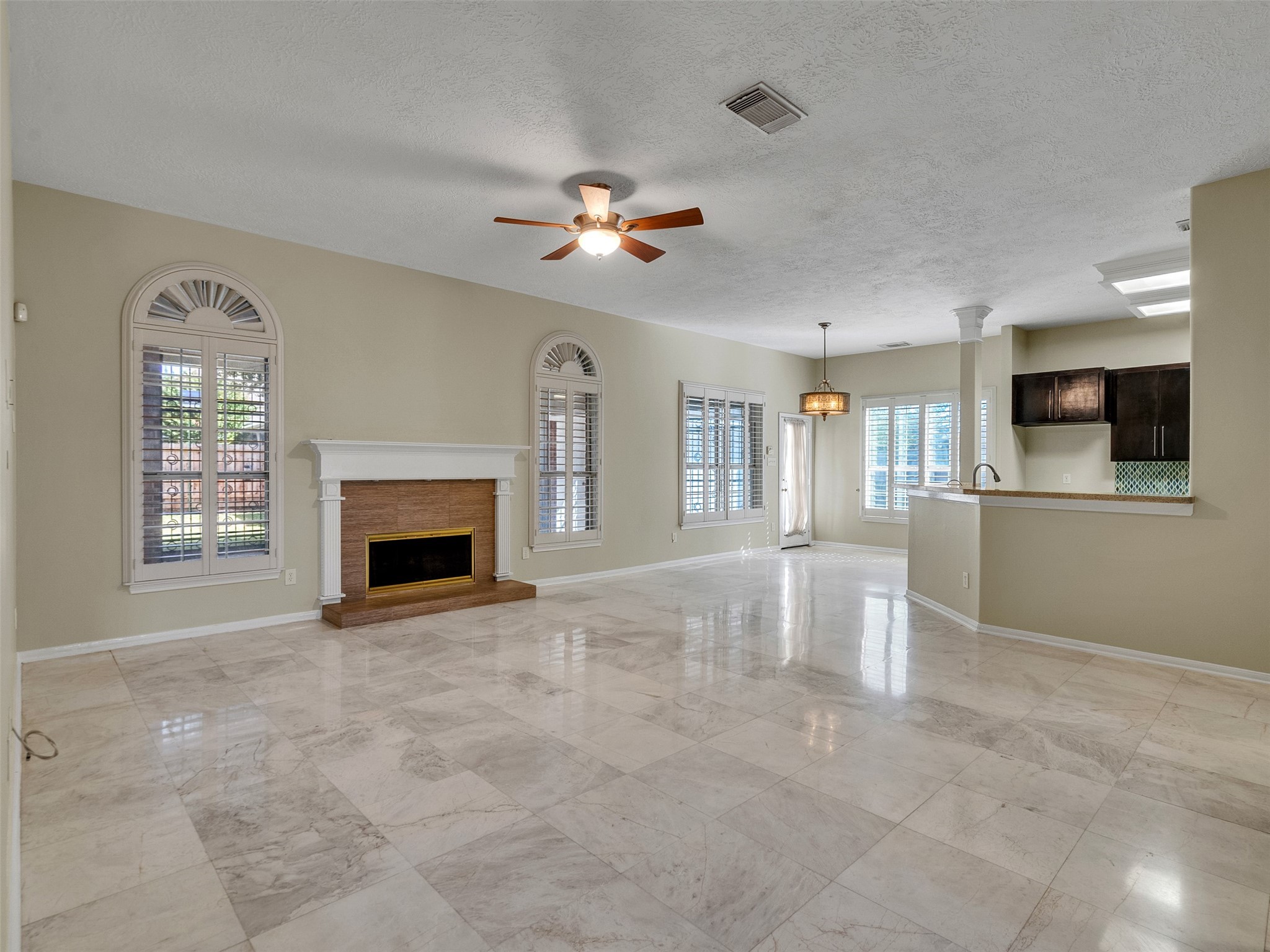 4414 Santee Drive Baytown, TX 77521 - Photo 18 of 50 a view of a livingroom with a fireplace a ceiling fan and windows