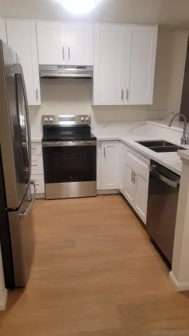 a kitchen with stainless steel appliances granite countertop a stove a sink and a refrigerator