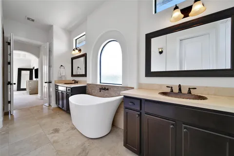 a spacious bathroom with a double vanity sink mirror and bathtub